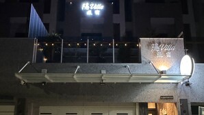 Un bâtiment avec une enseigne au néon indiquant « Villa » et une porte de garage.