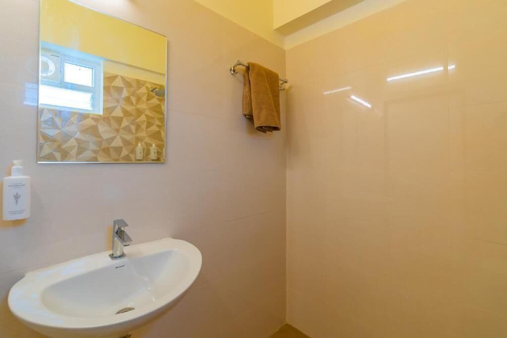 A bathroom with a white sink, a mirror, and a towel rack.