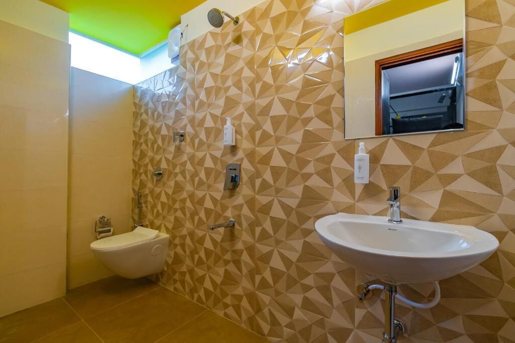 A bathroom with a bidet, a sink, and a mirror.