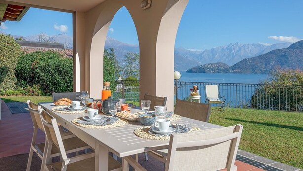 A table set for breakfast with a scenic mountain view. - My Rental Homes - Villa Cremia  with infrared sauna, Jacuzzi and lake view (Vignola)