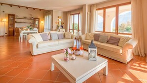 A spacious living room with a sofa set, a dining table, and a view of the mountains through large windows. - My Rental Homes - Villa Cremia  with infrared sauna, Jacuzzi and lake view (Vignola)