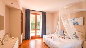 A bedroom with a bed, a bedside table, a nightstand, a window with curtains, a radiator, and a painting on the wall. - My Rental Homes - Villa Cremia  with infrared sauna, Jacuzzi and lake view (Vignola)