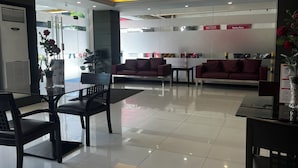 A modern hotel lobby with a seating area, a reception desk, and a 'Parking Rules' sign. - Hotel Sogo EDSA Shaw Blvd (Mandaluyong)