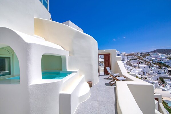 A white-walled building with a pool and a view of a white village. - My Rental Homes - Caldera Suite outdoor Jacuzzi, terrace and sea view (Fira)