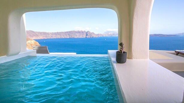 Une piscine à débordement offrant une vue sur la mer et les falaises.