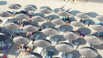 Relax under the shade of our thatched umbrellas, surrounded by comfortable beach chairs and loungers.