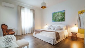 A bedroom with a bed, a chair, a lamp, and a painting on the wall. - Sun Stone with garden and pool - My Rental Homes (Trapani)