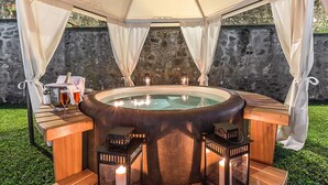 A hot tub with a wooden bench and two lanterns, surrounded by a canopy and stone wall. - My Rental Homes - Villa Monterchi with pool set in a wonderful panoramic position (Monterchi)