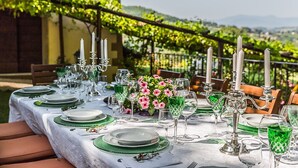 A table set for a meal with plates, glasses, and a flower arrangement. - My Rental Homes - Villa Monterchi with pool set in a wonderful panoramic position (Monterchi)