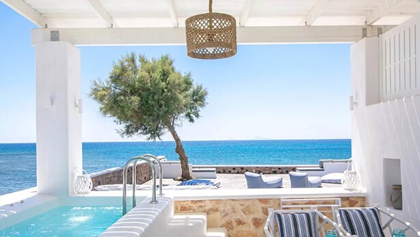 A poolside area with a view of the sea, a pergola, and outdoor seating. - Maison Ranya - My Rental Homes (Exomytis)