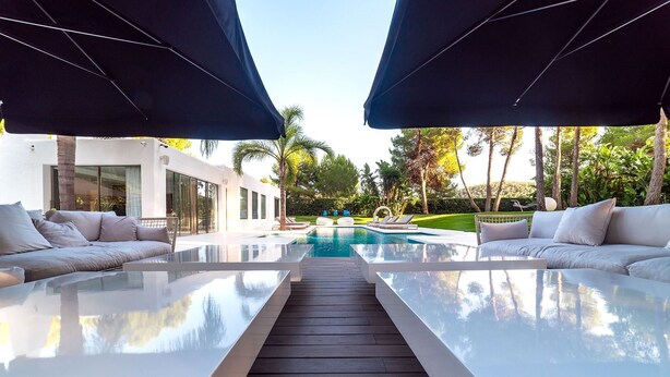 A modern outdoor pool area with a glass table, lounge chairs, and umbrellas. - My Rental Homes - Villa Sound luxury property with pool and privacy (San Jose)