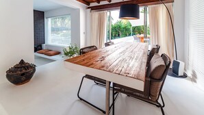A modern dining area with a wooden table, metal chairs, and a black pendant lamp. - My Rental Homes - Villa Sound luxury property with pool and privacy (San Jose)