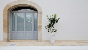 A building with a grey door and an arched entrance. - My Rental Homes - Villa Salentina with private pool and large private garden (Cutrofiano)
