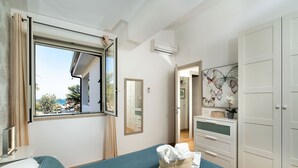 A bedroom with a bed, a window, a mirror, a dresser, and a wardrobe. - Apartment Ippocampo with terrace - My Rental Homes (Noto)