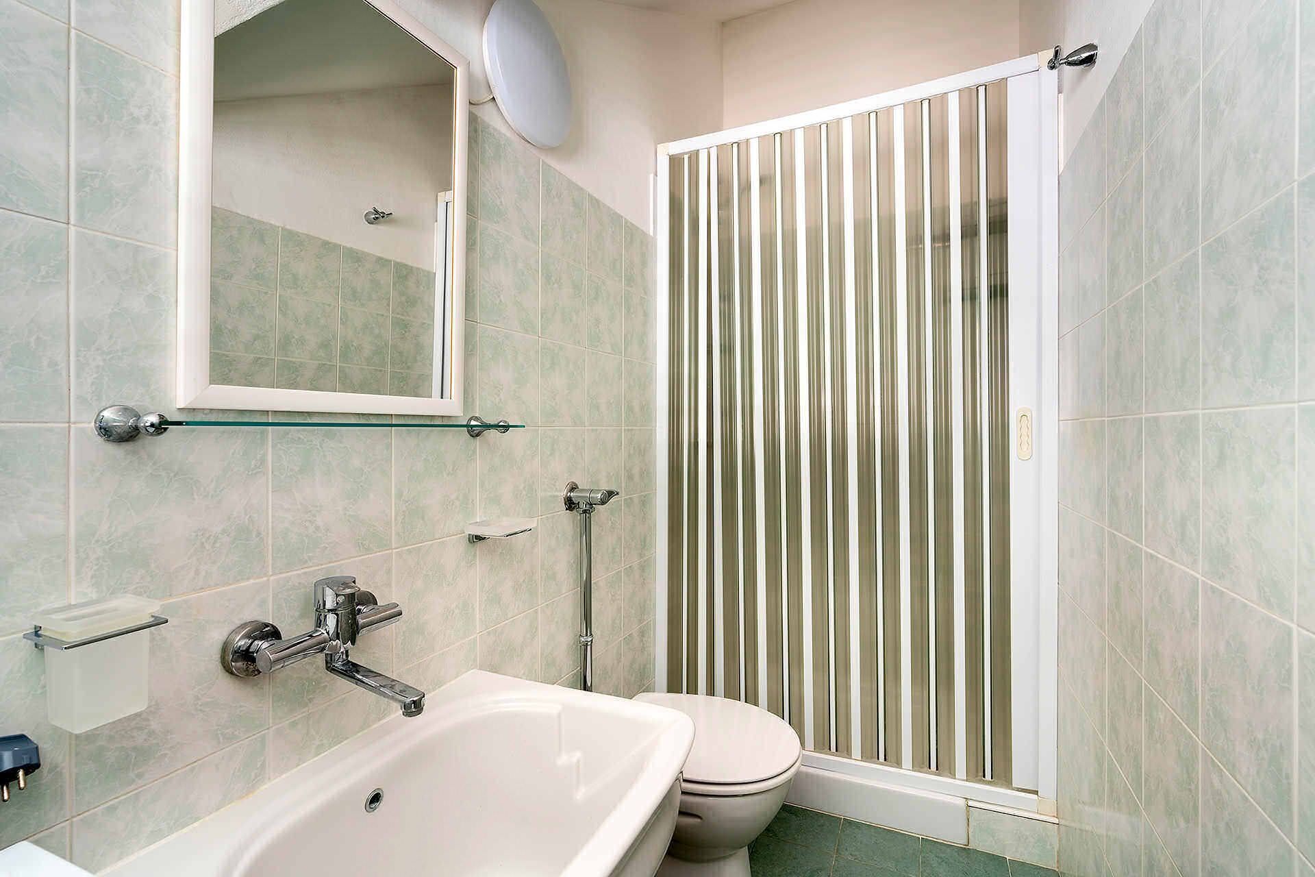 Ein Badezimmer mit Badewanne, Toilette und Duschkabine.