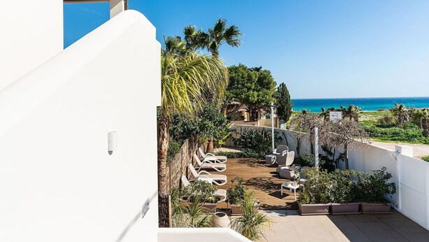 A balcony with a view of the ocean, outdoor seating, and a garden area. - Apartment Ippocampo with terrace - My Rental Homes (Noto)