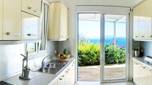 Een moderne keuken met een groot raam en uitzicht op zee.