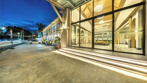 A modern building with large glass windows, a concrete entrance, and a well-lit interior. - A.Z. Sunrise Resort & Fitness Club (Choeng Thale)