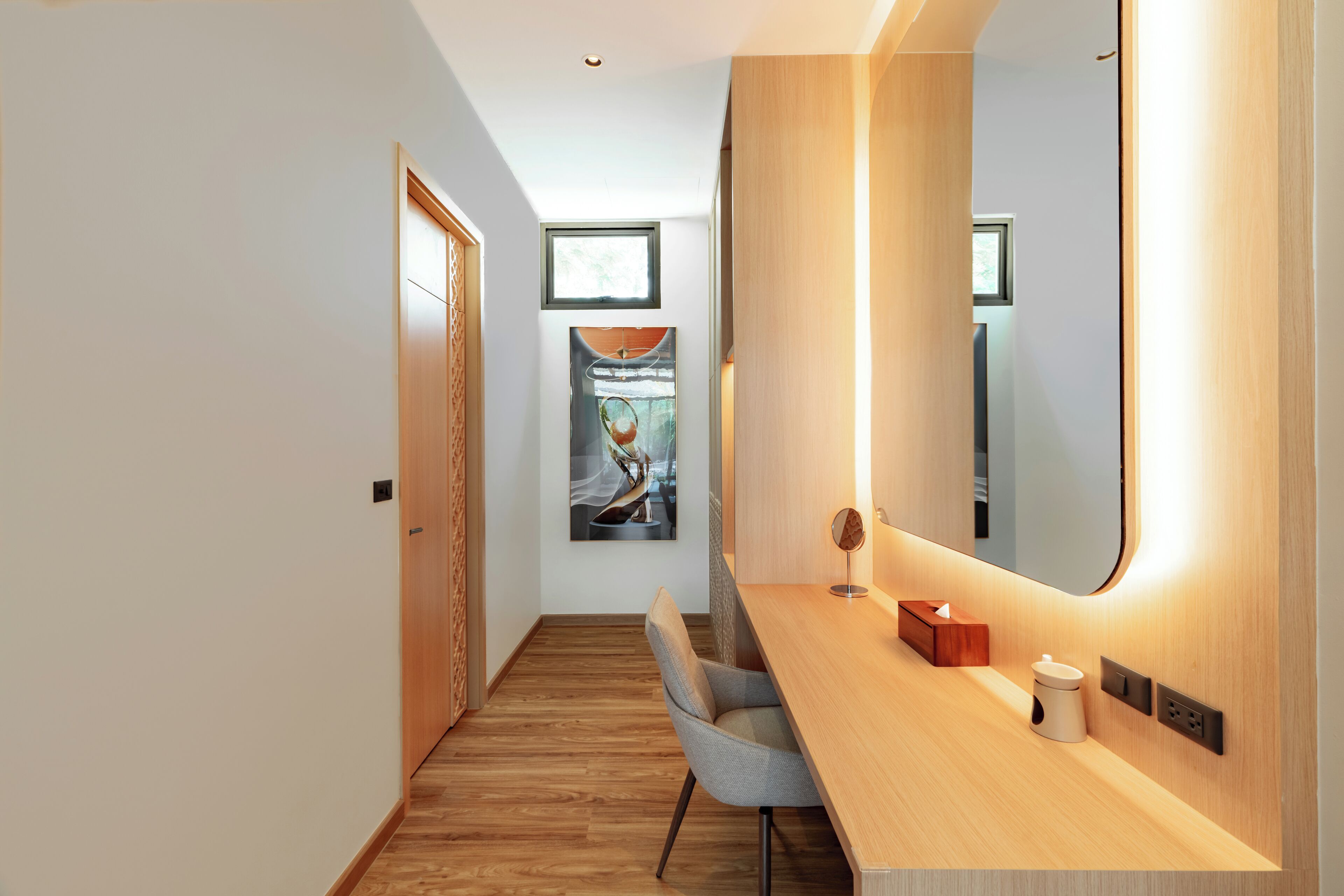 A modern bathroom with a wooden vanity, a mirror, and a towel rack.