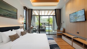 A modern hotel room with a large bed, a TV, a desk, and a view of a pool and buildings. - A.Z. Sunrise Resort & Fitness Club (Choeng Thale)