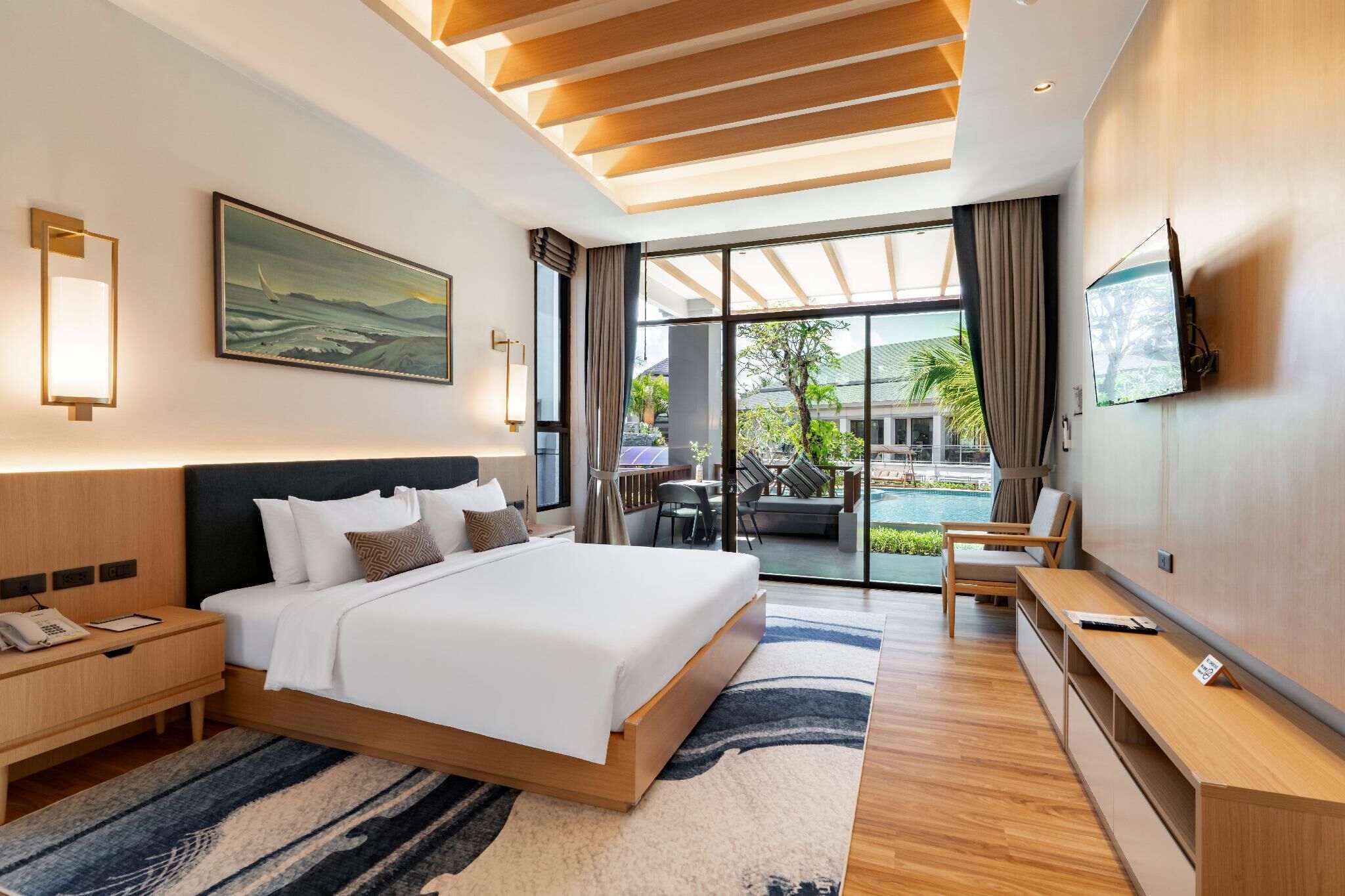 A modern hotel room with a large bed, a desk, a TV, and a view of the outdoors.