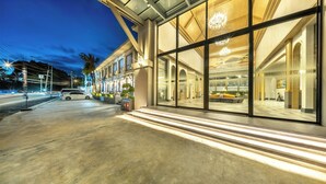 A modern building with large glass windows, a concrete entrance, and a well-lit interior. - A.Z. Sunrise Resort & Fitness Club (Choeng Thale)