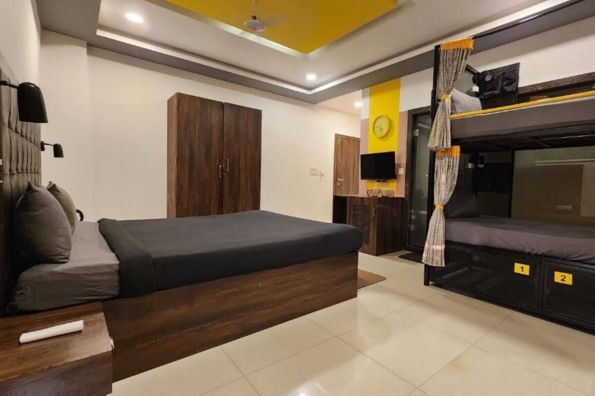 Een moderne slaapkamer met een groot bed, een stapelbed en een garderobe.