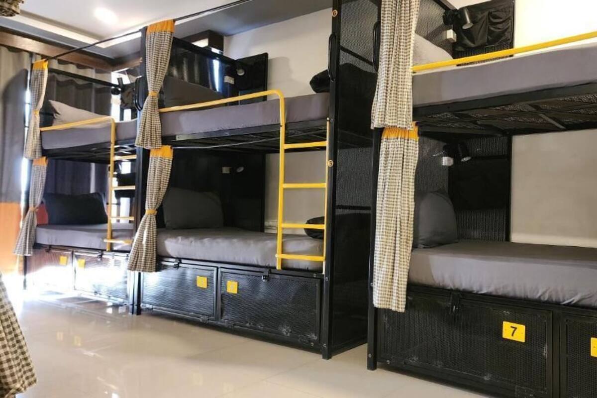 Een slaapkamer met een stapelbed, een bureau en een raam.