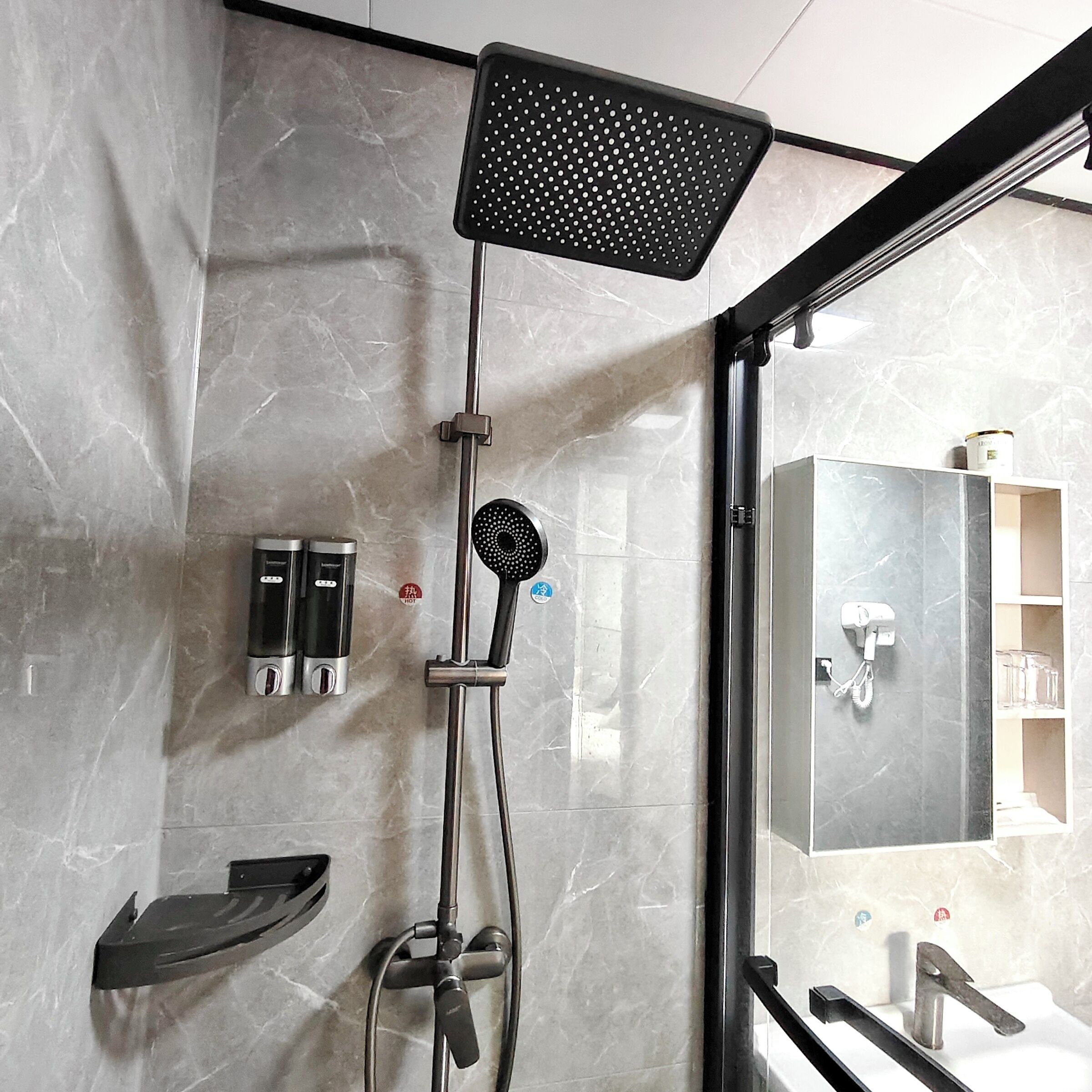 A modern bathroom with a shower, a sink, and a mirror.