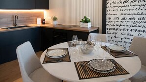 A modern kitchen with a dining area set for four. - Casa Mario with terrace and sea view (Sorrento)