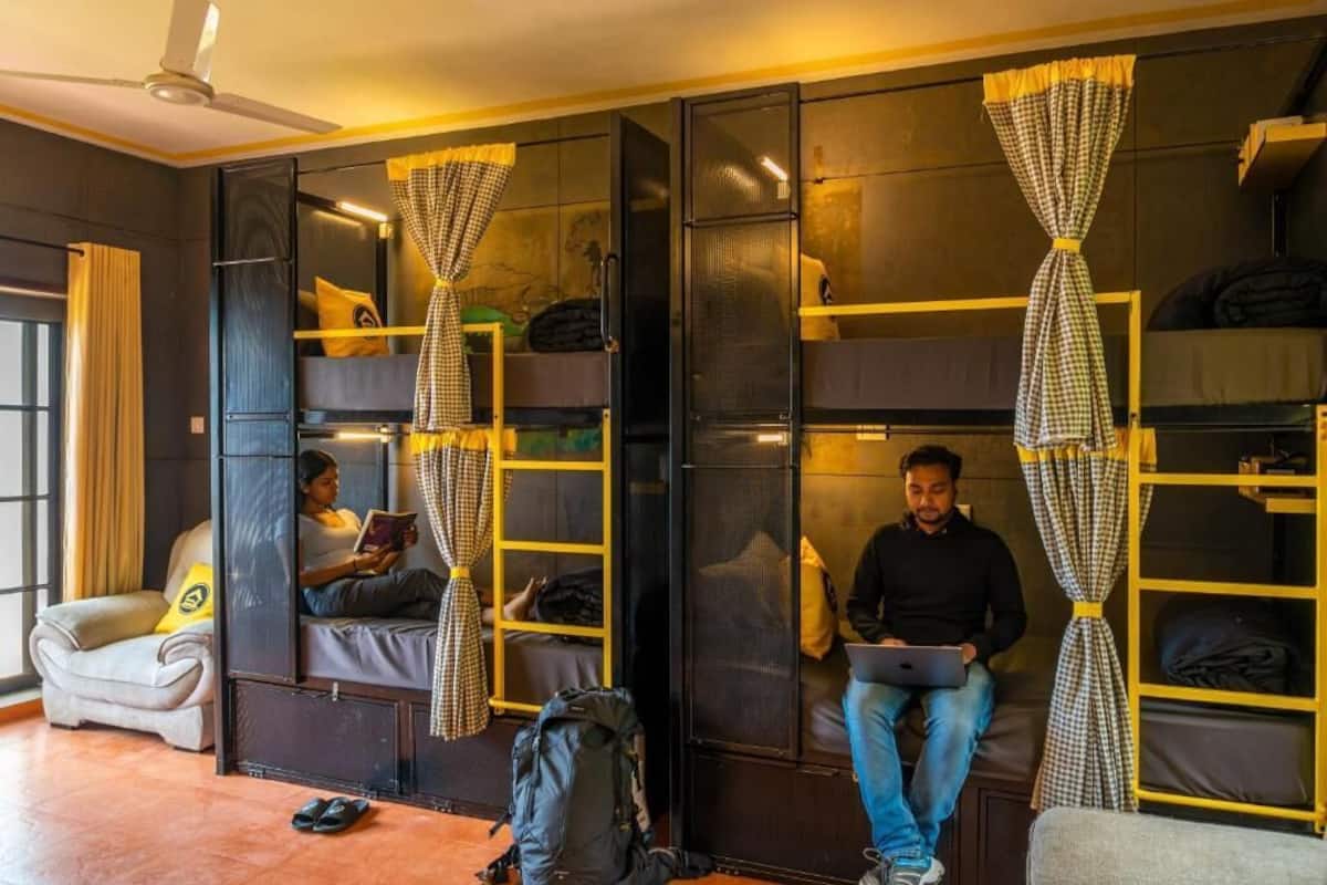 A room with bunk beds, a desk, and a chair.