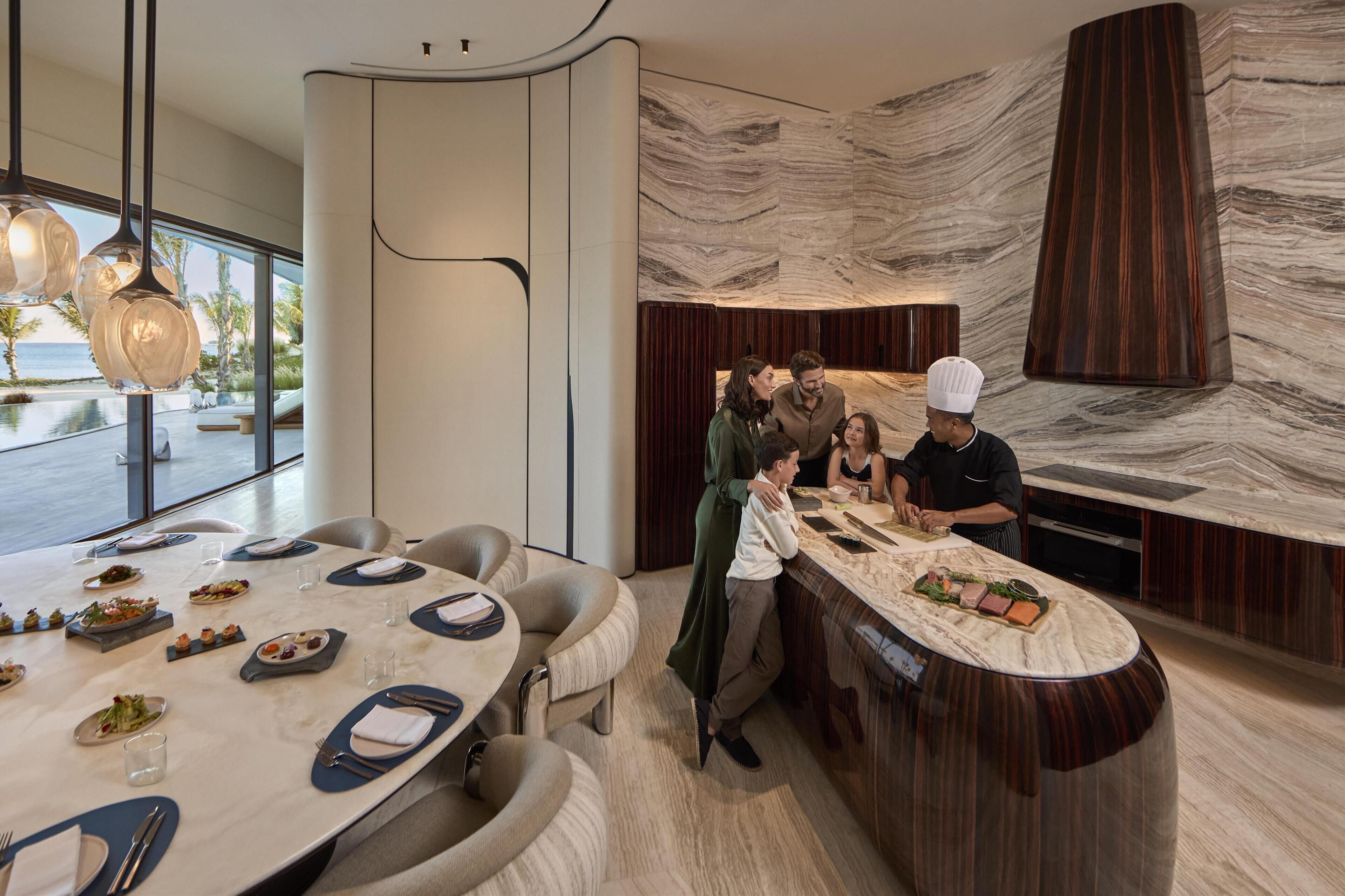 A modern dining area with a marble countertop, round tables, and a view of the ocean.