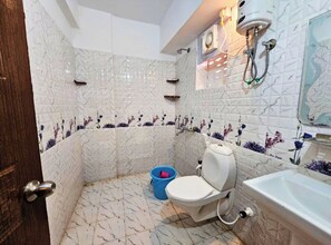 Bathroom features a toilet, sink, and shower with handheld showerhead.