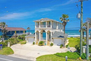 A two-story house with a balcony, a garage, and a view of the ocean. - High Tide Estate | Team Joseph Ellen (Ponte Vedra Beach)