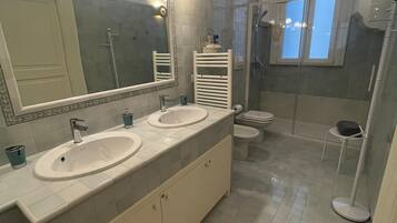 Een douche, een haardroger, een bidet, handdoeken