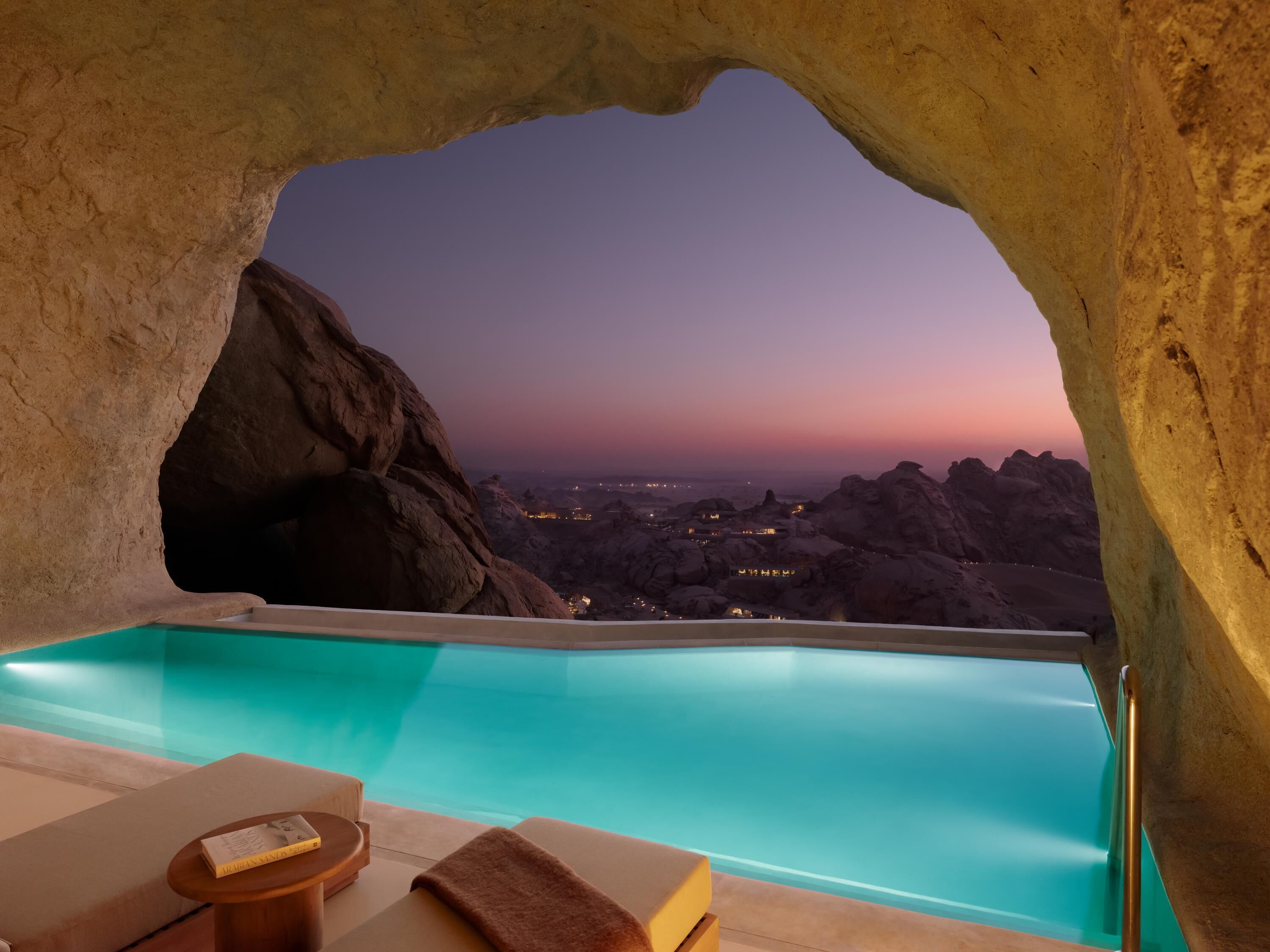 Un spa con piscina, vistas de la ciudad y una gran formación rocosa.