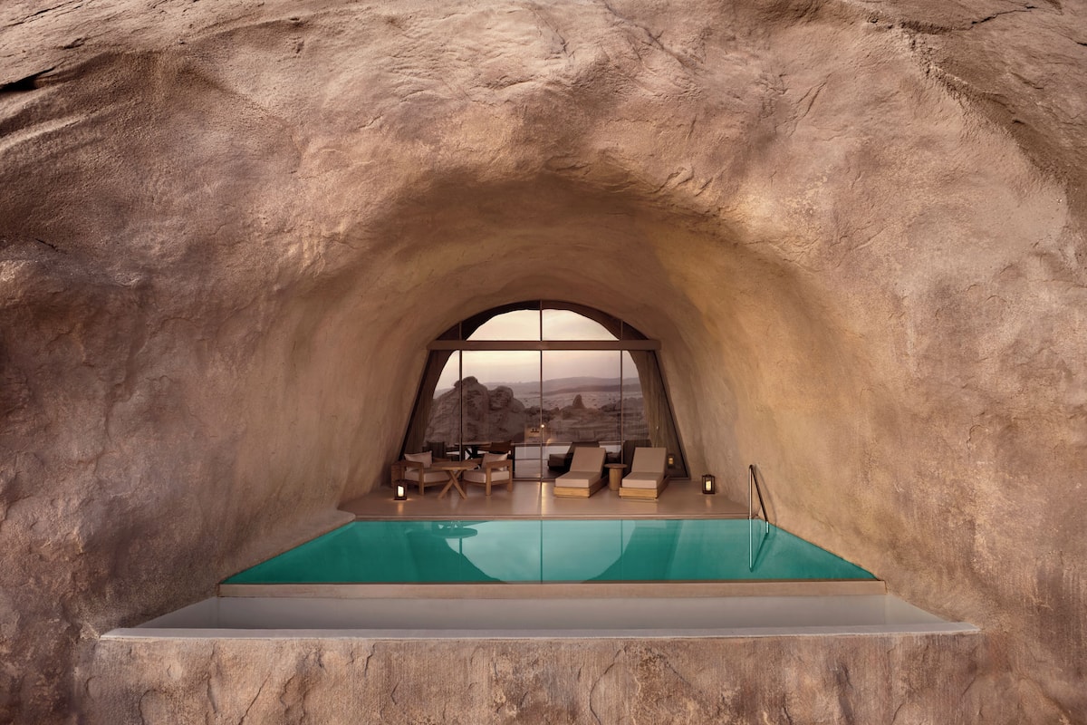 An arched viewing area with a pool, seating, and a view of a mountainous landscape.
