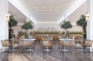 Un comedor amplio con techos altos, luz natural y una disposición central de asientos.