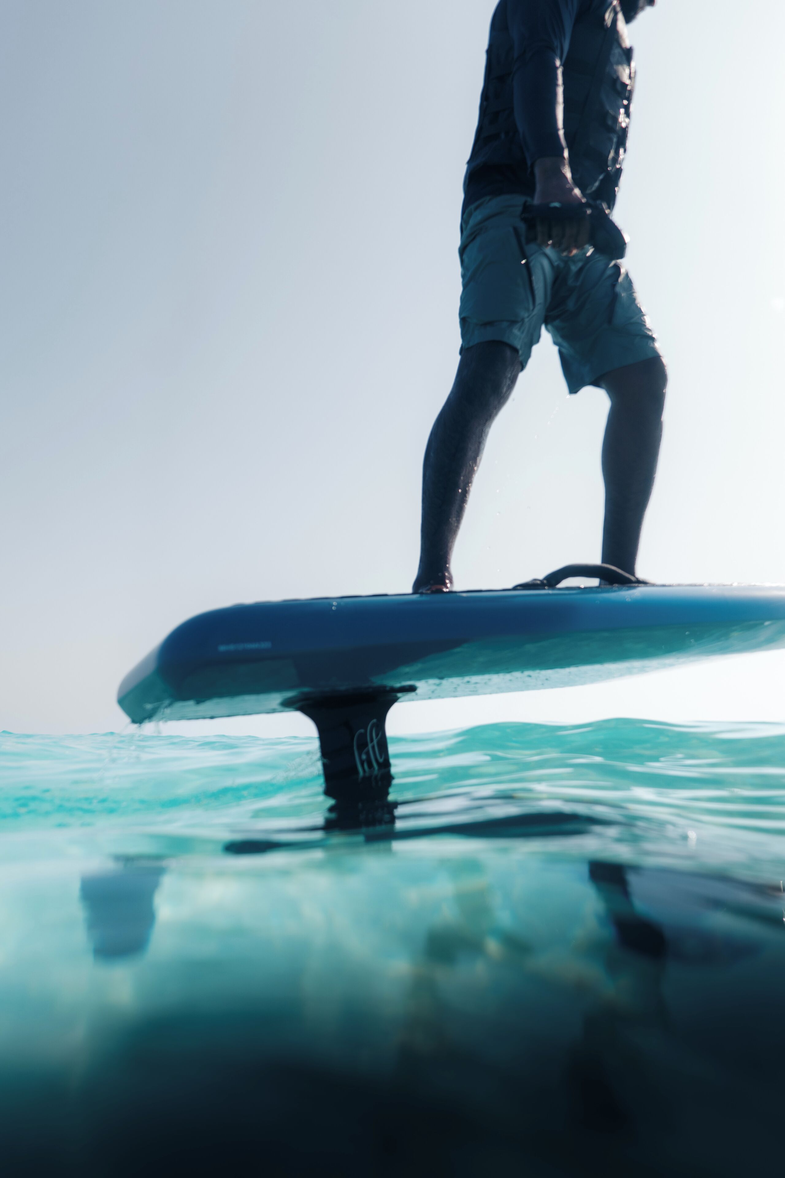 Una persona de pie sobre una tabla de surf en el agua.