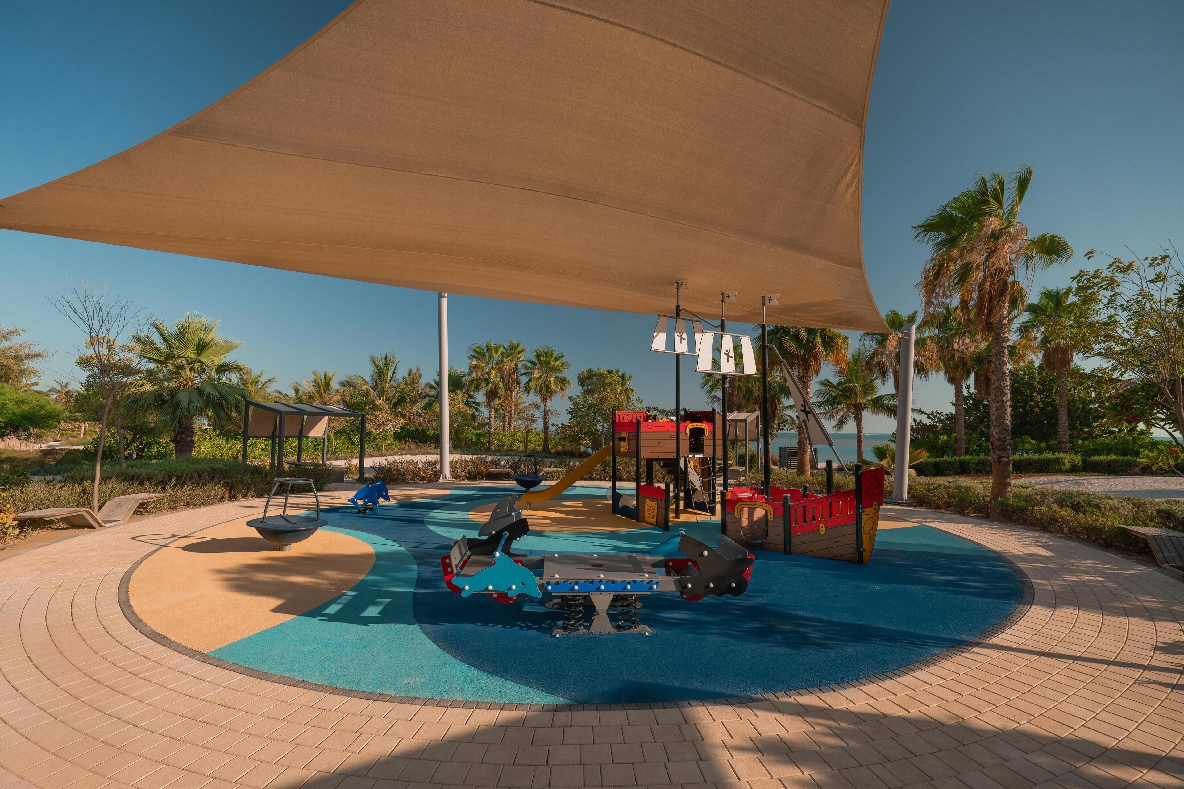Un parque infantil con columpios, tobogán y estructura para escalar.