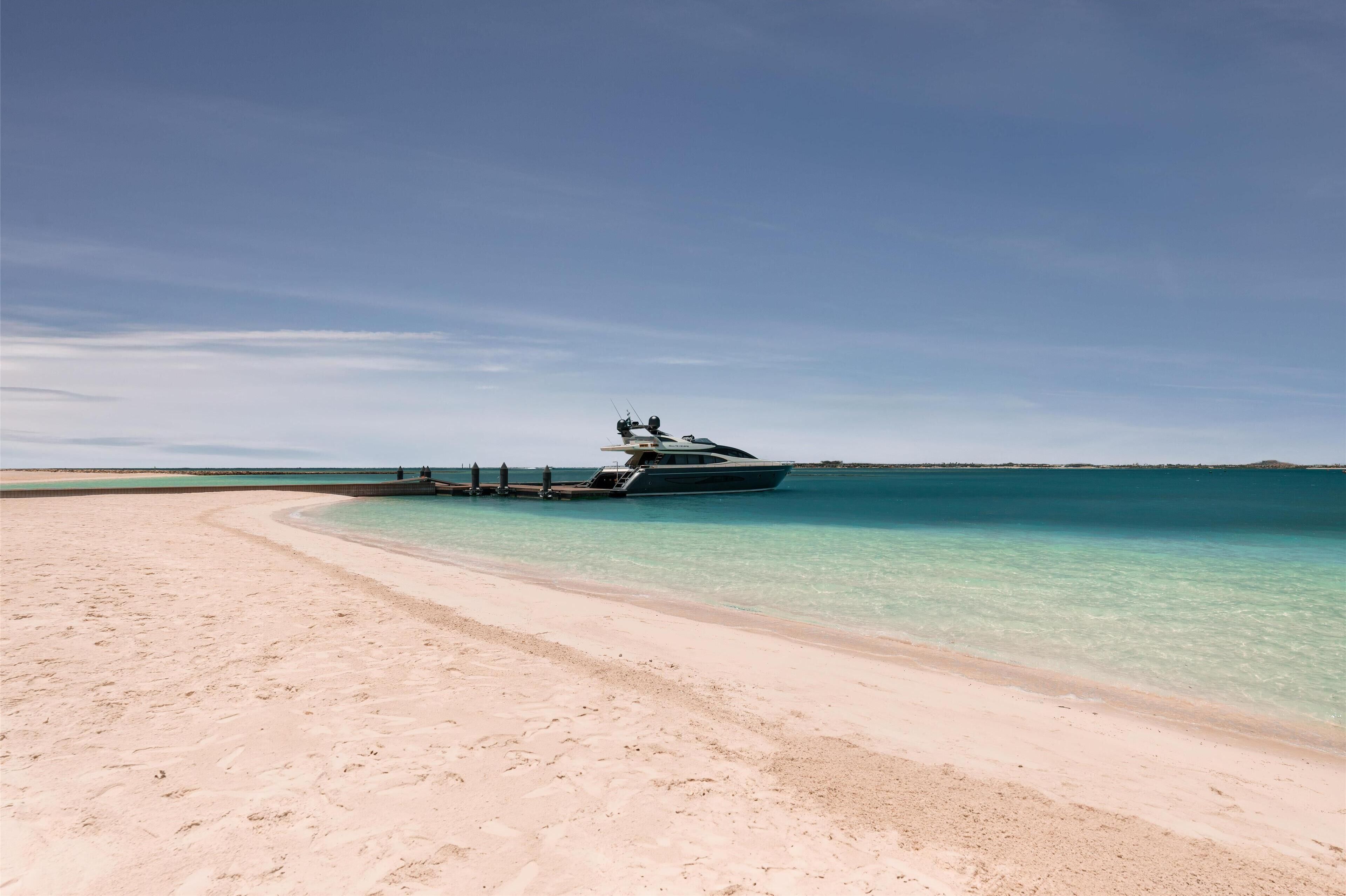 Une plage avec un bateau amarré près du rivage.
