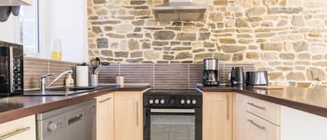 Enjoy cooking in this well-equipped kitchen with a central island, oven, and stovetop.