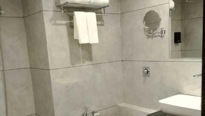 A modern bathroom with a toilet, sink, and shower. - The Blues Hotel (Sanand)