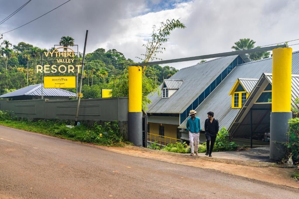 A resort entrance with a sign for Vytheri Valley Resort, a hostel, and a staircase leading to the building.