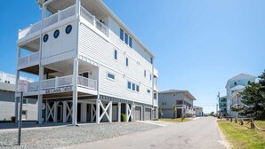 Een meerlaags gebouw met een balkon op de tweede verdieping en een garage-ingang.