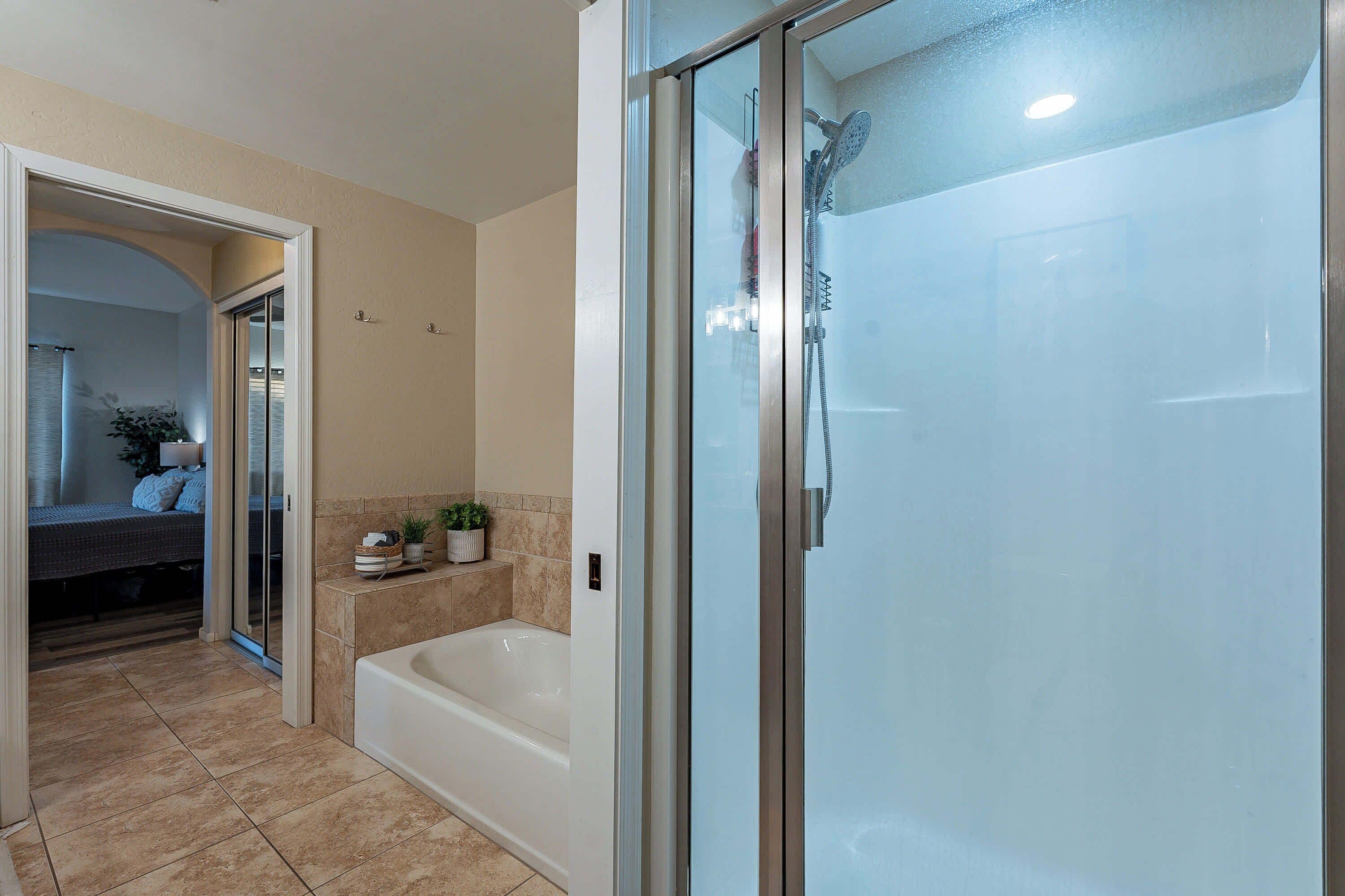 A modern bathroom with a glass-enclosed shower, a bathtub, and a walk-in shower.