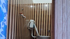 Une salle de bain avec des toilettes, une douche et un mur en bois.