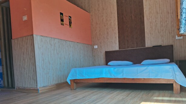 Une chambre à coucher avec un cadre de lit en bois, une couvre-lit bleue et une tête de lit en bois.