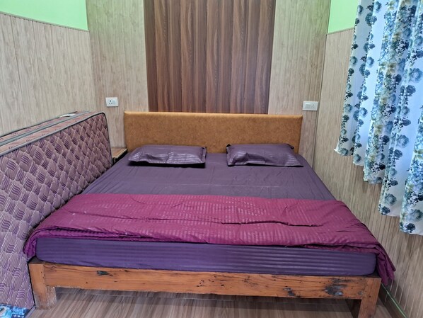 Un letto singolo con struttura in legno, testiera e materasso rivestito di viola.