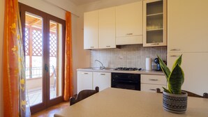 Una cocina con armarios blancos, estufa a gas y lavavajillas.